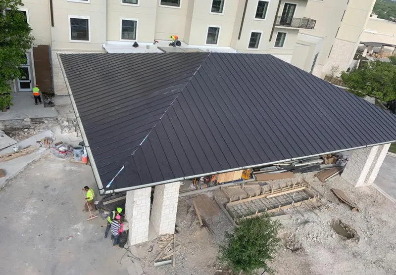 Metal roofing installation team working on a commercial building in Flushing